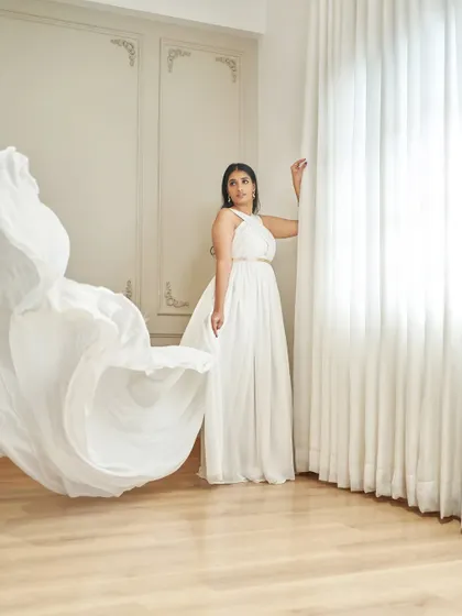 Meet 'Paul', a Grecian-inspired white gown. It has a bold criss-cross halter neck and a breezy georgette skirt that flows beautifully with every movement.