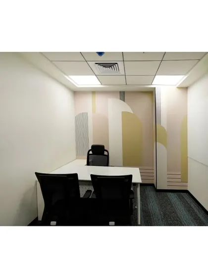 A small, private cabin or focus room with a pastel-colored geometric mural. This space offers a quiet retreat for individual work or one-on-one conversations, away from the buzz of the open office.