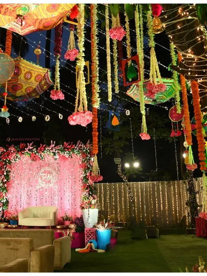 A closer view of the evening stage, with a shimmering pink backdrop and colorful hanging decor. This setup is perfect for a lively Mehndi or Sangeet night.