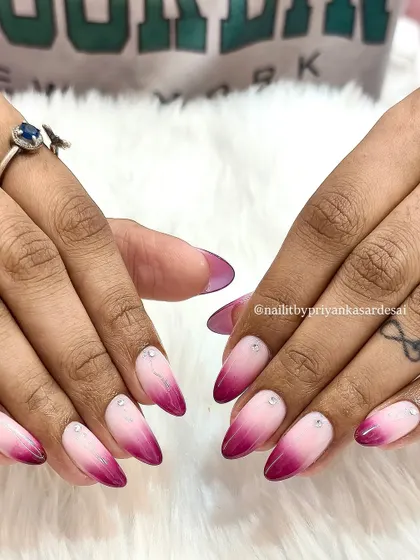 Another view of the stunning pink and magenta ombré nails, showing off the sharp almond shape and the flawless color blend.