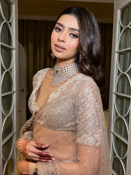 This pose highlights the beautiful V-neck of the blouse and the way the makeup enhances the bride's features. It's a look that is both sexy and elegant.