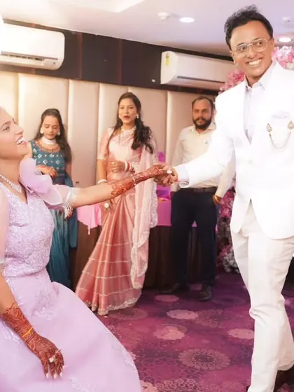 A fun moment from an engagement party, with the groom leading his bride to the dance floor.