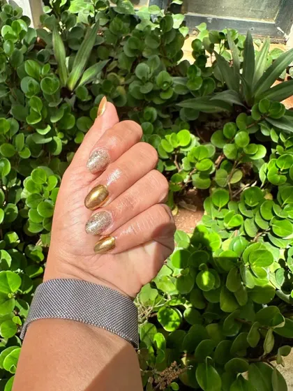 A beautiful outdoor shot of the gold glitter and foil nails, showing off their brilliant shine in the sunlight.