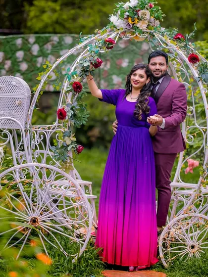 A beautiful portrait of a couple with a Cinderella carriage, adorned with flowers. The bride's purple and pink gown adds a vibrant touch to this fairy-tale scene.