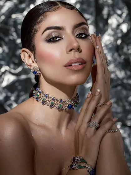 A beauty shot that emphasizes the hands and jewelry, showing the complete styled look from the choker down to the rings.
