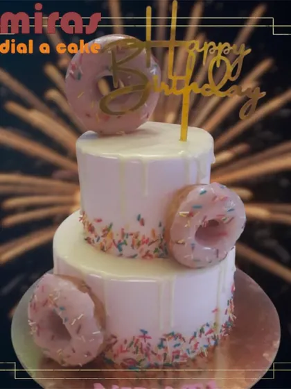 Why choose between cake and donuts when you can have both? This fun two-tier drip cake is adorned with delicious-looking donuts and colorful sprinkles.