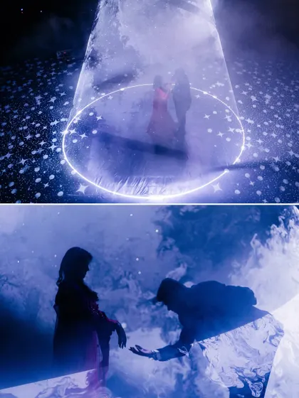 A romantic couple performance under a spotlight. The use of smoke and floor graphics creates a magical, 'dancing on clouds' effect for the couple's special moment.
