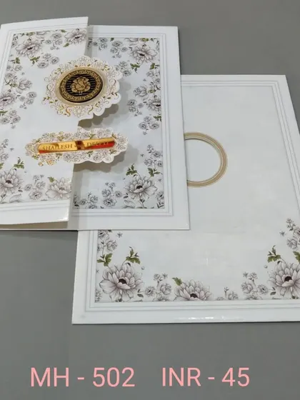 A clean white invitation with a floral print and unique gate-fold closure. The design is modern and interactive, with gold emblems for a touch of luxury.