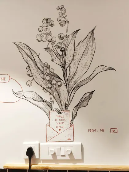 A close up of the 'Smile, Be Kind, Sleep, Repeat' message tucked into a botanical drawing, adding a positive and hidden detail for observant customers.