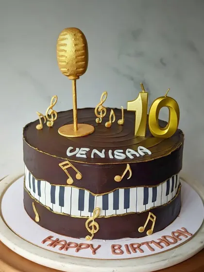 For a music lover, this cake features a piano keyboard, a golden microphone, and floating musical notes.