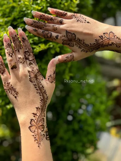 A delicate and modern design featuring a vine of butterflies flowing down the arm and hand. This style is perfect for an engagement or a sangeet party.