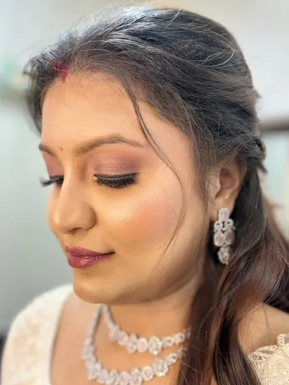 A close-up of a soft and romantic party look, featuring a flawless base and subtle pink eyeshadow.