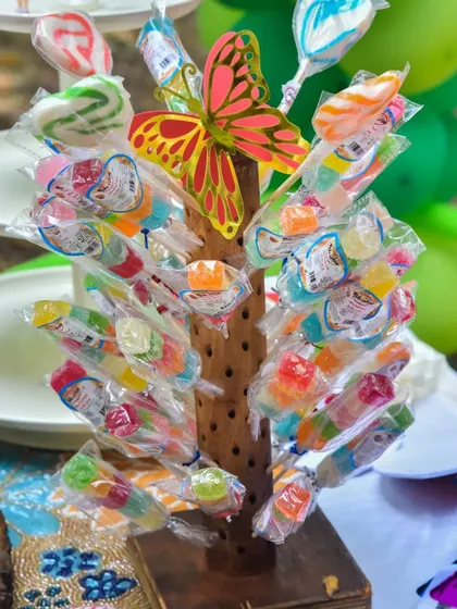A colorful candy tree serves as both a decoration and a fun treat station for the kids at a birthday party.