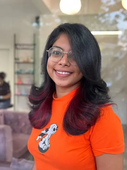 A smiling client showing off her new playful red tips.