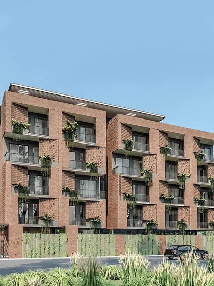 The facade of Nandi Souls is designed to incorporate greenery, with planters integrated into the brickwork. This approach helps the multi-story building feel connected to its natural setting at the foothills of Nandi Hills.