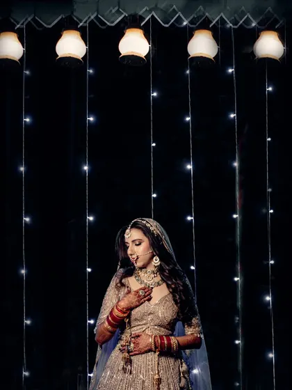 A beautiful portrait of the bride against a curtain of fairy lights, creating a dreamy and magical ambiance for her wedding photos.