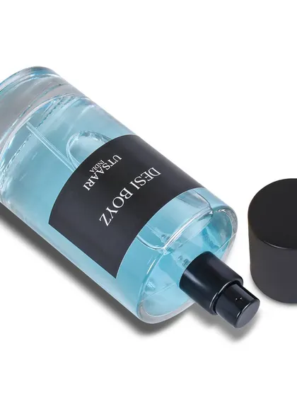 A clean, simple shot of a perfume bottle on its side, with a slight shadow, perfect for showcasing the product's shape and branding.