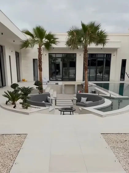 Another perspective of the sunken lounge area, framed by two beautiful palm trees. This design creates an intimate and exclusive space for relaxation by the pool.