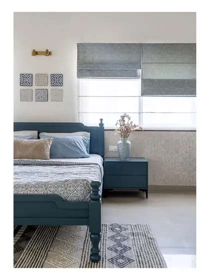 A detail of the master bedroom, showing how patterns are layered within a single color palette. The blue bed, patterned rug, and tiled artwork create a cohesive and calming look.