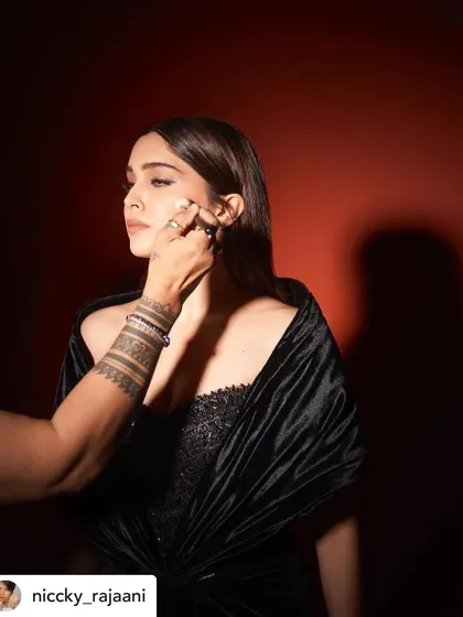 A candid moment of me doing a final touch-up on Sharvari. This shows the hands-on nature of my work as a celebrity makeup artist.