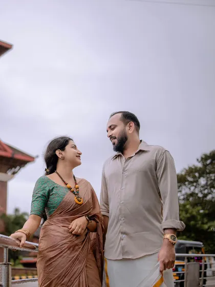A quiet, conversational moment on a bridge or walkway, with the city in the background.