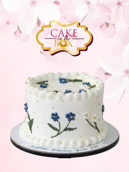 A simple and sweet birthday cake with delicate, hand-piped blue and white flowers. This minimalist design proves that sometimes less is more, offering a touch of classic charm.
