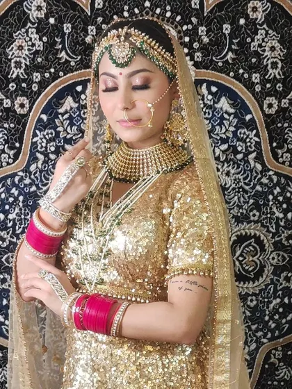 A beautiful bridal portrait showcasing a heavy Kundan and pearl set against a golden sequin lehenga.