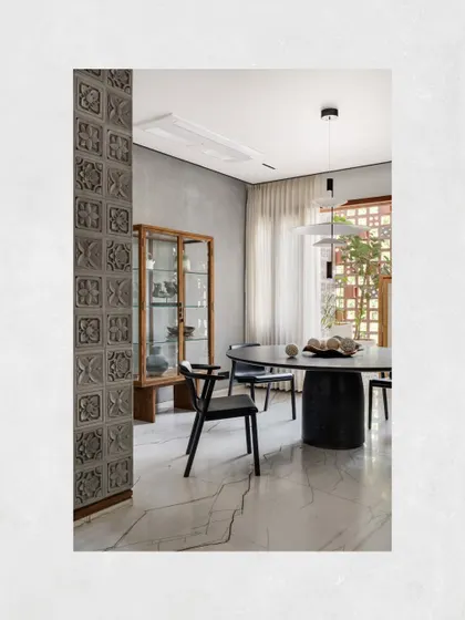 The dining area in Kamala Residence, defined by its Vastu-compliant placement and textured cement-clad walls that add depth and visual interest.