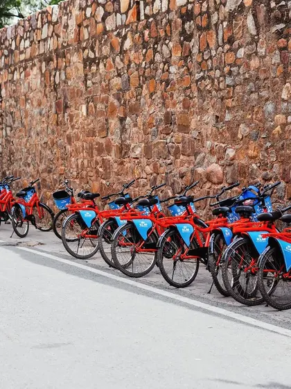 Our fleet of signature red and blue cycles, all lined up and ready for an adventure. Just park your worries, hop on, and let's explore together.