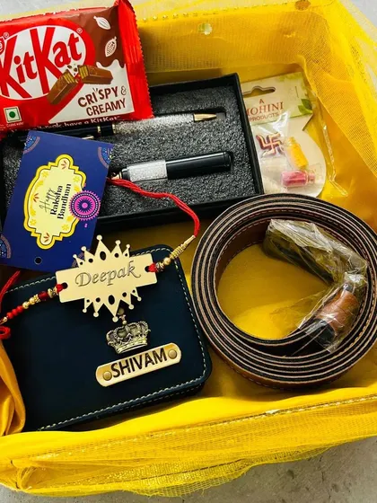 A large Rakhi gift basket including a personalized wallet, a rakhi with a crown charm, a belt, a pen, and chocolates.