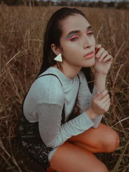 From the 'UTOPIA' series, published in Elegant Magazine. The styling combines a simple grey top with a delicate lace slip dress, creating a layered look that feels both vulnerable and strong in the natural field setting.