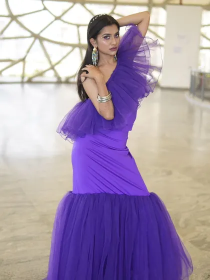 This purple mermaid-style gown with ruffled details is modern, chic, and incredibly flattering. It's a great choice for a cocktail party or formal event.