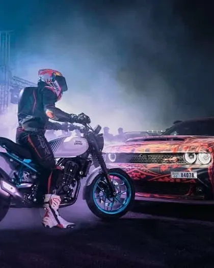 Our performances are a carefully choreographed dance between cars and bikes. This shot captures a moment of synergy between a stunt rider and a drifting muscle car, a highlight of our live event packages.