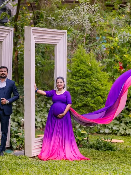 A creative maternity portrait using our oversized white photo frames to create a unique and artistic composition in the garden.
