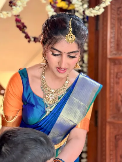 A candid moment during the ceremony. The makeup is soft and natural, focusing on a flawless complexion and subtly defined eyes, perfect for a daytime event.