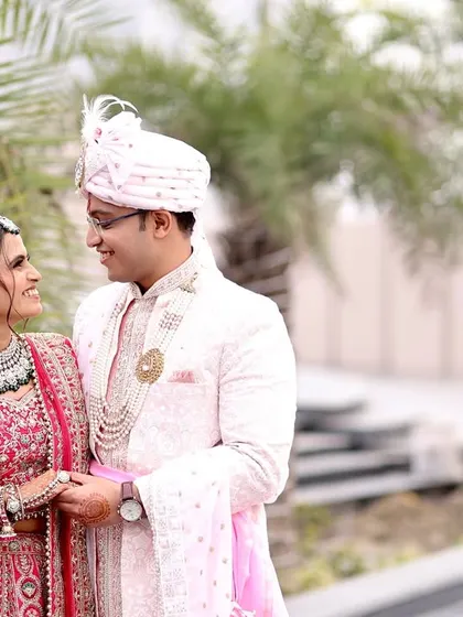 A candid close-up of the couple sharing a loving gaze, highlighting the bride's stunning jewelry and the subtle elegance of the groom's outfit.