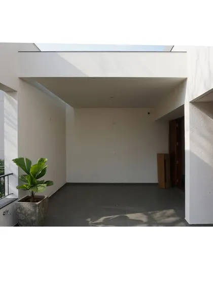 The RT Nagar residence terrace during its final stages. The clean white walls and grey flooring create a minimalist canvas.