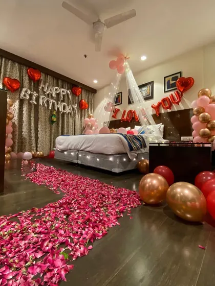 This angle shows the full rose petal pathway leading to the decorated bed, creating a grand and romantic entrance into the room.