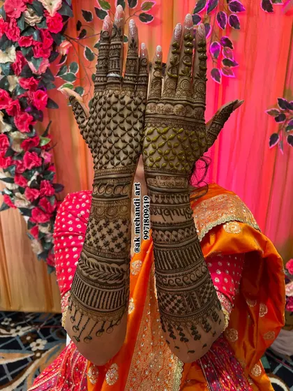 A bride holding up her hands, showcasing a full jaal or net pattern that covers the entire back of her hands and arms.