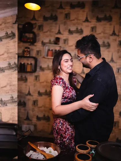 A candid shot of the couple sharing a loving gaze while cooking. It’s these unscripted interactions that make for the most authentic pre-wedding photos.