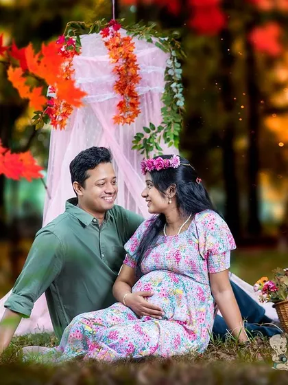 A duplicate of a beautiful outdoor picnic setup, this image shows a relaxed and romantic setting for a couples maternity shoot. The couple's connection is clear as they sit together.