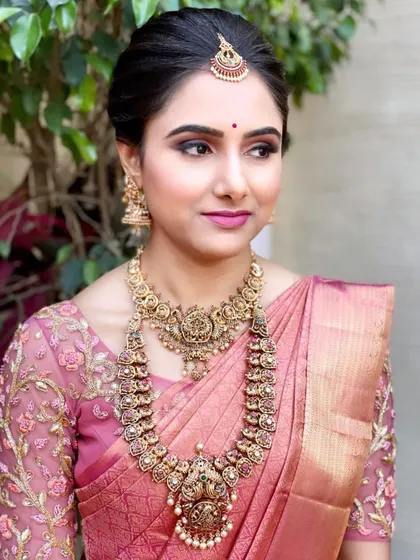 A side profile of Shwetha's Muhurtham look, highlighting the clean updo and the harmony between her makeup and traditional accessories.