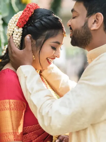 The groom gently caresses his bride's face, her smile shy and happy. It's a small, tender gesture that reveals the depth of their affection.