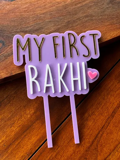 A close-up of our "My First Rakhi" acrylic topper, showing the clean lines and 3D effect of the layered materials.