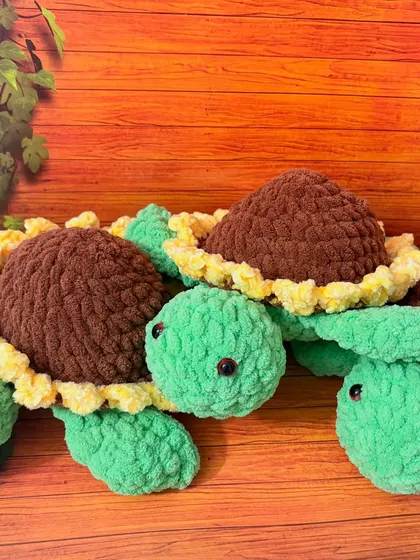 These cuddly tortoises are made with an ultra-soft, velvety plush yarn that's perfect for hugs. This group shows my sunflower-themed design, featuring a cheerful green body and a shell that looks just like a blooming sunflower.