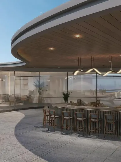 The rooftop bar and lounge area is designed with curved architectural elements that echo the building's form. It provides a sophisticated setting for corporate entertaining or casual team gatherings, blending indoor comfort with an outdoor setting.