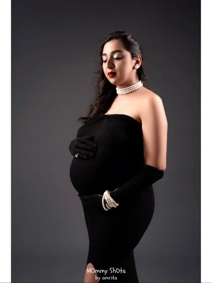 A glamorous maternity shoot look. We went for old Hollywood glamour with a classic red lip, winged liner, and elegant pearls to create a timeless and sophisticated portrait.
