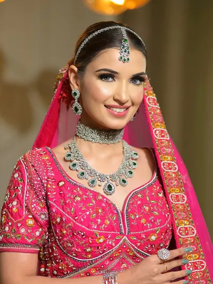 A vision in pink and diamonds. This bride's look is all about modern elegance, with a clean pink eyeshadow, winged liner, and a radiant complexion.