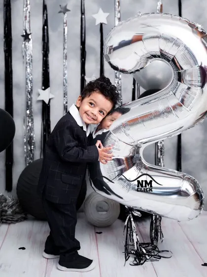 Hugging the number two balloon. We encourage playful interactions with props to bring out the most natural smiles during milestone sessions.