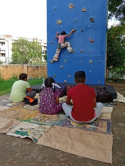 A family watches as a young climber practices bouldering on the Davangere wall. We encourage community participation and offer a welcoming environment for all.